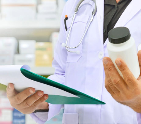 Male doctors hands examining a medicine bottle while holding a folder highlighting over-the-counter drugs in Canada